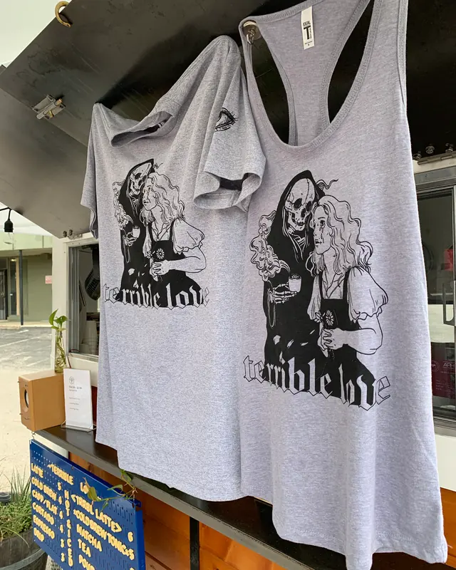 Terrible Love vest tops hanging up at the trailer